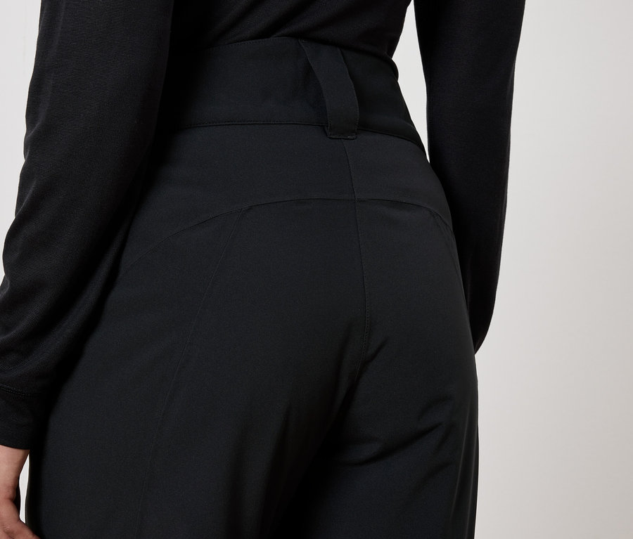 Rückansicht einer Frau in schwarzen Hosen und schwarzem Oberteil.