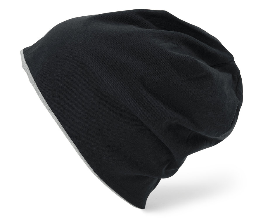 Eine schwarze, gestrickte Mütze mit grauem Futter liegt auf einem weißen Hintergrund.