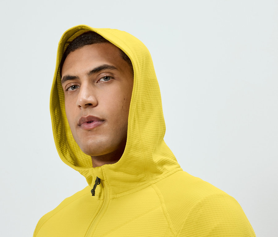 Porträt eines Mannes mit gelbem Kapuzenpullover mit Reißverschluss.