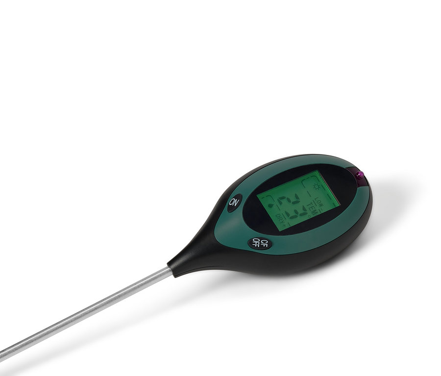 Ein schwarzes und grünes Bodenmessgerät mit einem silbernen Stab liegt auf einem weißen Hintergrund.