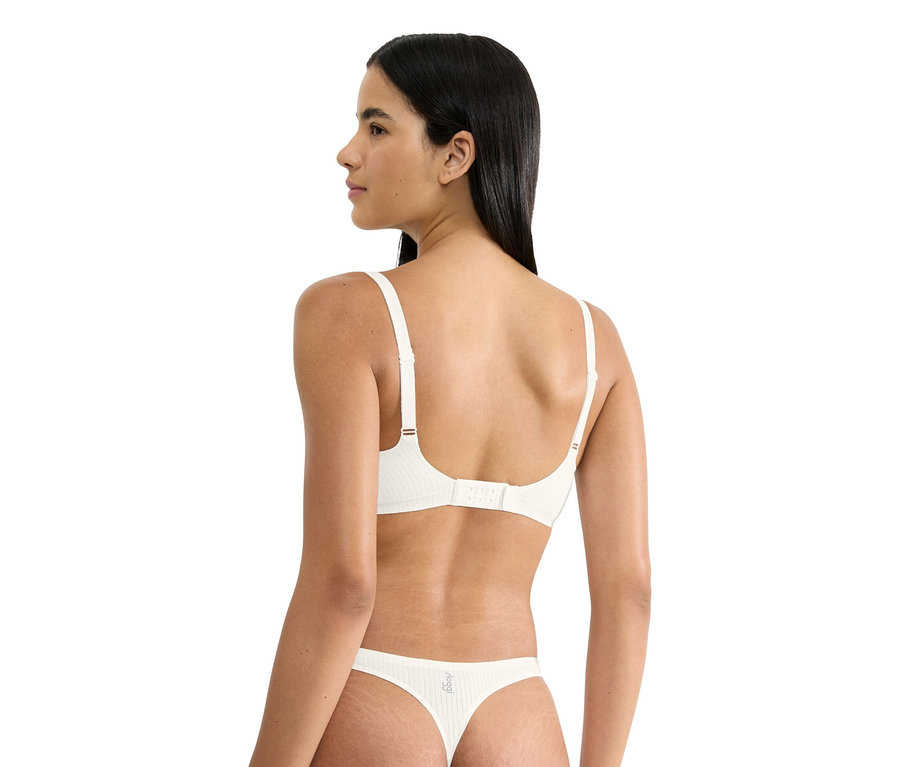 Frau trägt weißen BH und Tanga, von hinten gesehen.