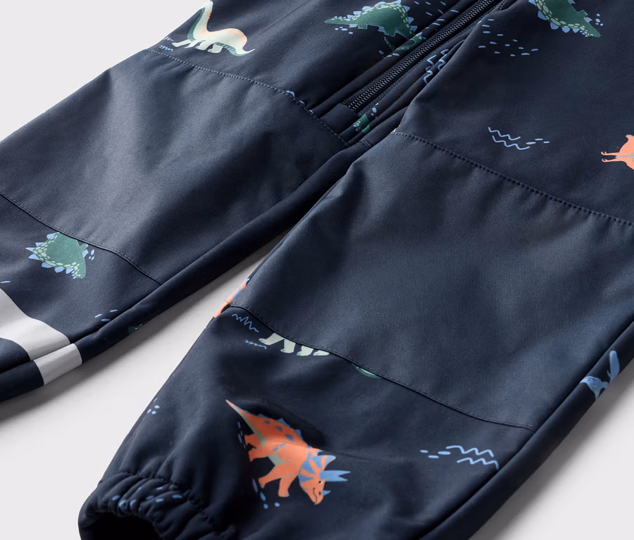 Nahaufnahme einer marineblauen Hose mit Dinosaurier-Muster, Reißverschluss oben und weißem Streifen am Bein.