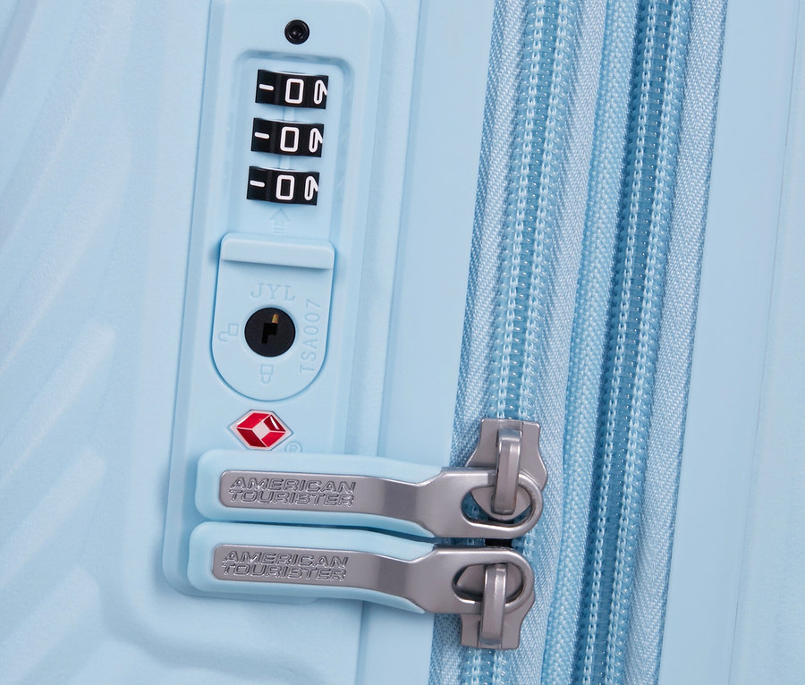 Detailansicht eines hellblauen American Tourister Koffers mit Zahlenschloss und Reißverschluss.