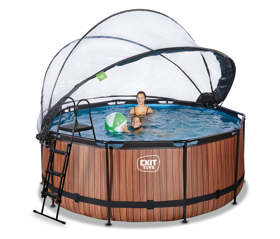 Zwei Personen, eine Frau und ein Kind, schwimmen in einem runden EXIT Pool-Set »WOOD« (ca. 360 cm) mit Holzoptik und transparenter Kuppelabdeckung. Das Kind hält einen grün-weißen Wasserball. Eine Leiter ist am Pool befestigt.