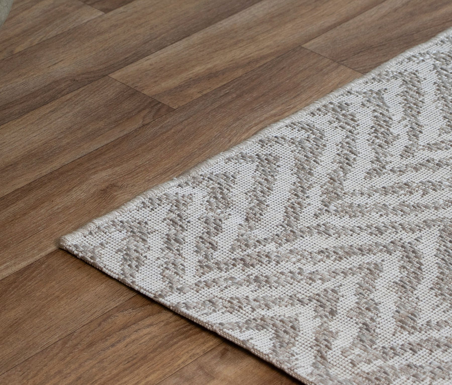 Outdoor-Teppich "Ecru Flow" mit hellem geometrischem Muster auf einem Holzfußboden.