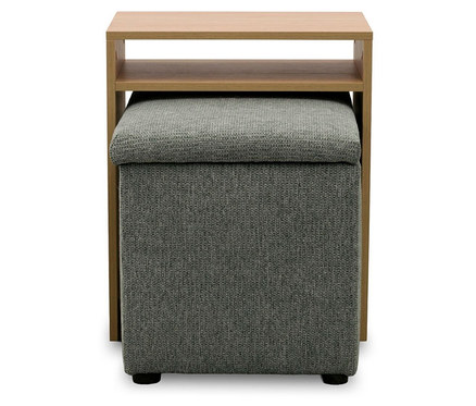Heller Beistelltisch aus Holz mit zwei Ablagen, unter dem ein grauer, gepolsterter Hocker steht.