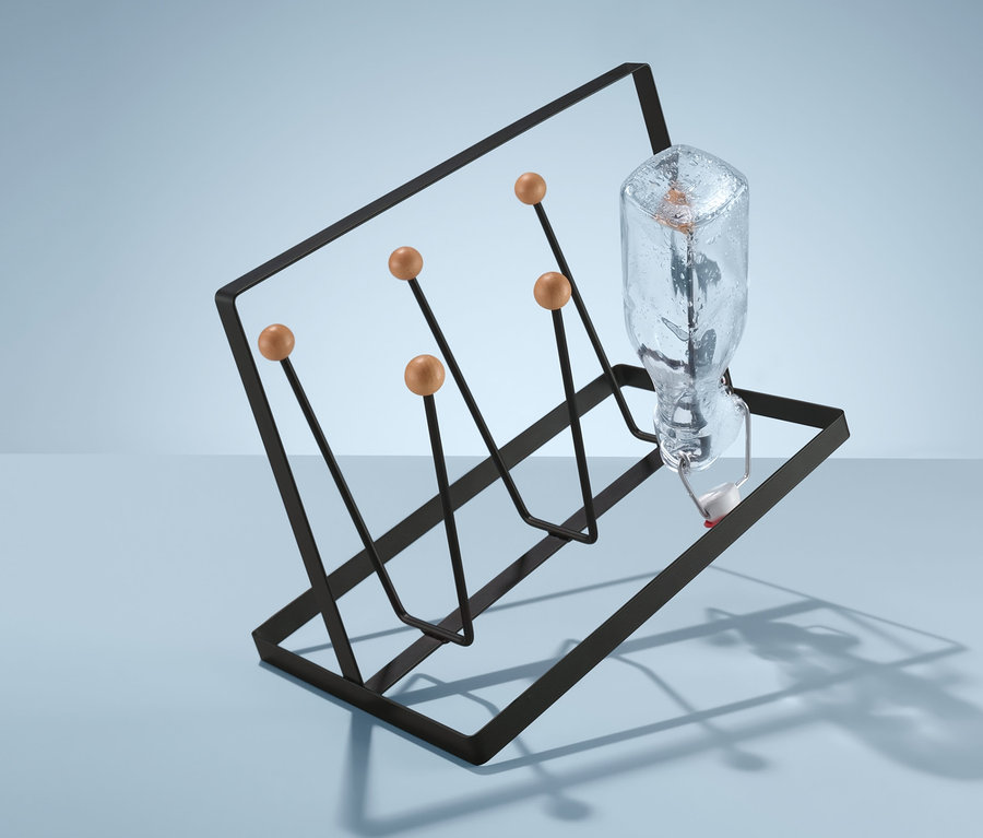 Eine Glasflasche steht auf einem Glas- und Becherständer.