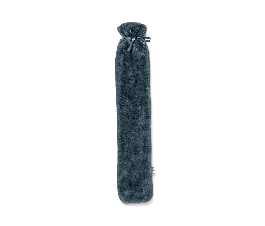 Eine blaue Schlauch-Wärmflasche mit Plüschbezug und Schleife liegt auf einem weißen Hintergrund.