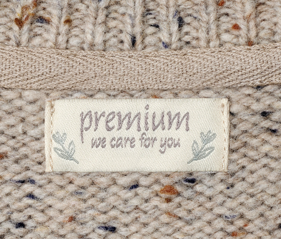 Detailansicht eines Strickpullovers mit Premium-Etikett.