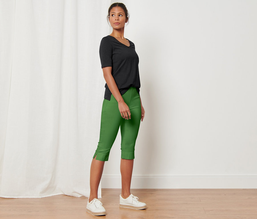 Frau posiert in grüner 3/4-Stretchhose.