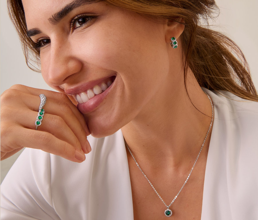 Lächelnde braunhaarige Frau trägt 925 Silber Creolen, 925 Silber Ring, 925 Silber Ring Wave und 925 Silber Kette.