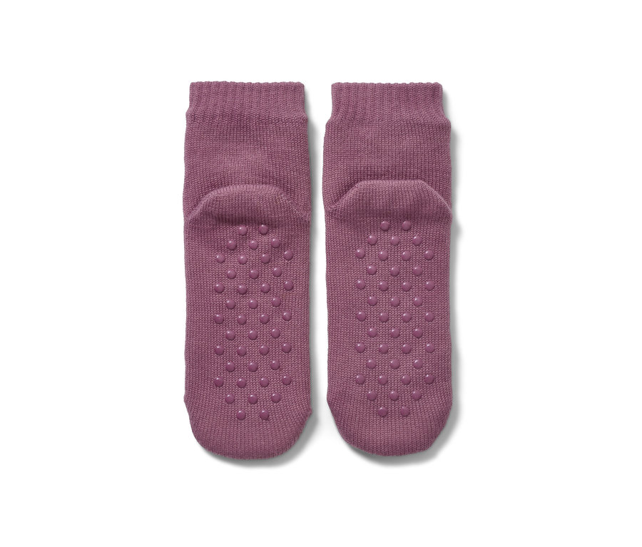 Zwei lila Hausschuh-Socken auf weißem Hintergrund.