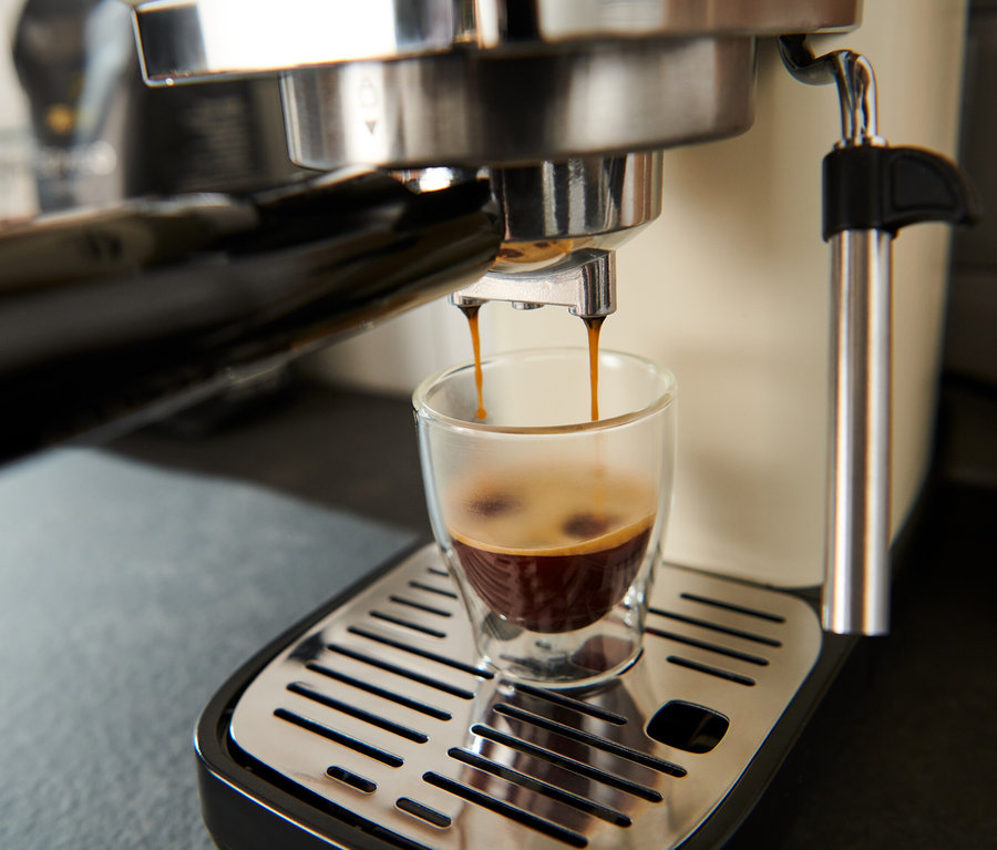 Espresso läuft aus einer creme »Lapressa« Siebträgermaschine in ein Glas.