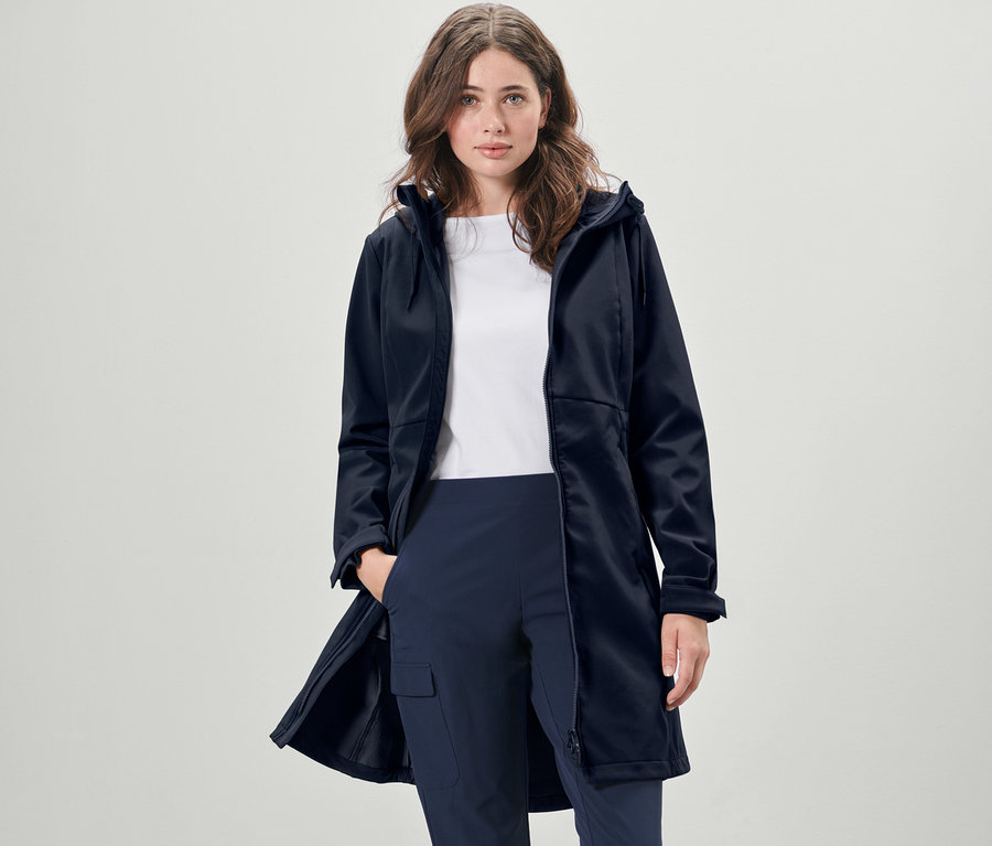 Frau trägt einen dunkelblauen Softshellmantel.