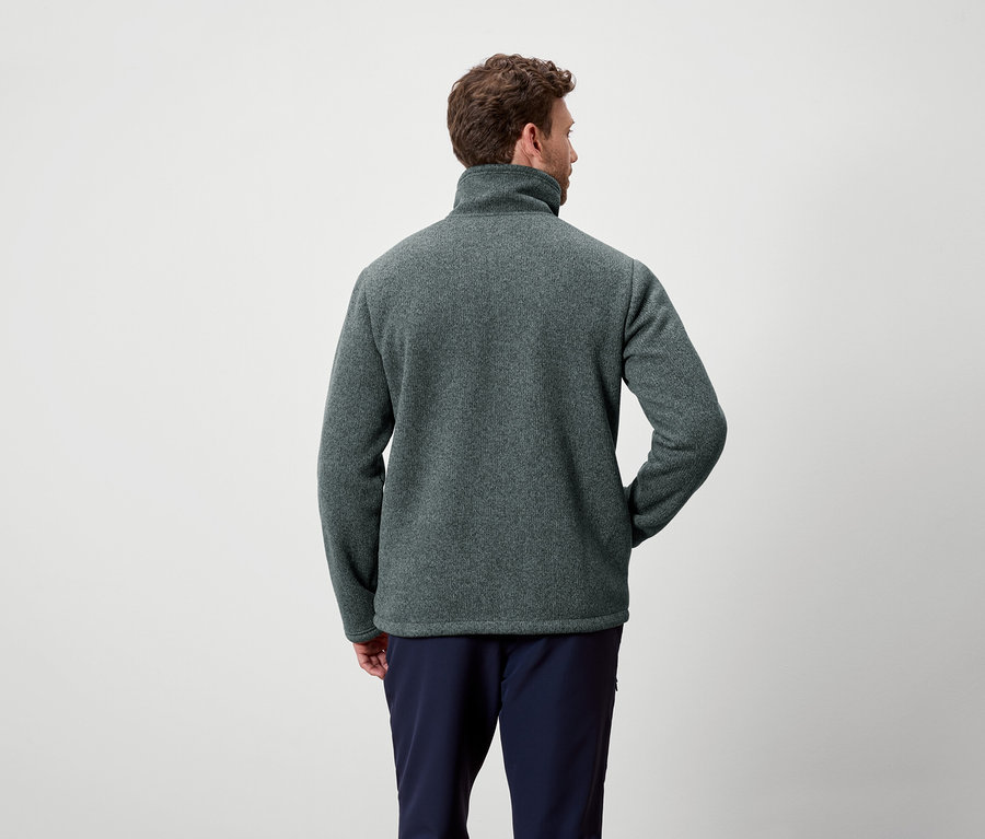 Mann von hinten trägt ein graugrünes Fleece und marineblaue Hosen.