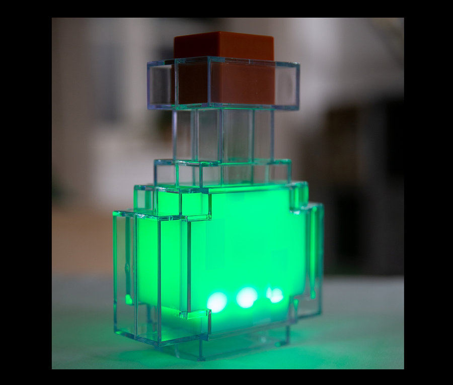 Eine leuchtende, grüne MINECRAFT LED Dekoleuchte in Form eines Tranks.