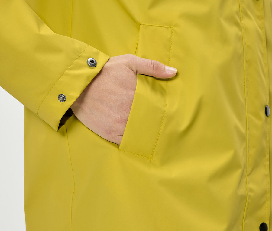 Hand in der Tasche einer gelben Jacke.