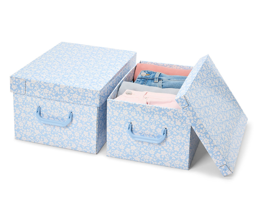 Zwei Aufbewahrungsboxen mit Deckel mit blauem Blumenmuster. Eine Box ist geschlossen und die andere ist offen und voll mit Kleidung.