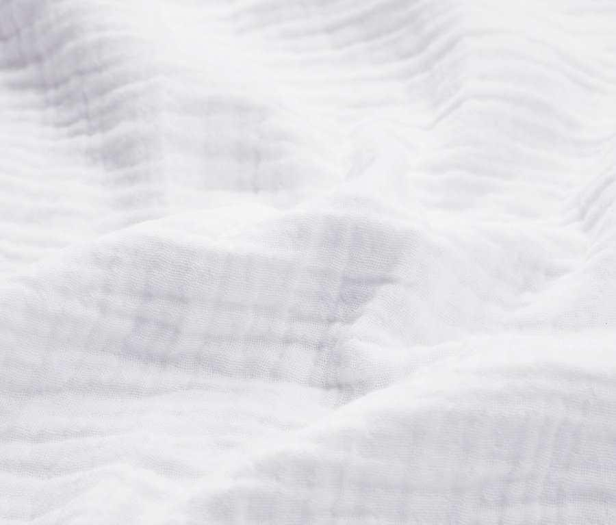 Detailaufnahme eines weißen, strukturierten Stoffes.