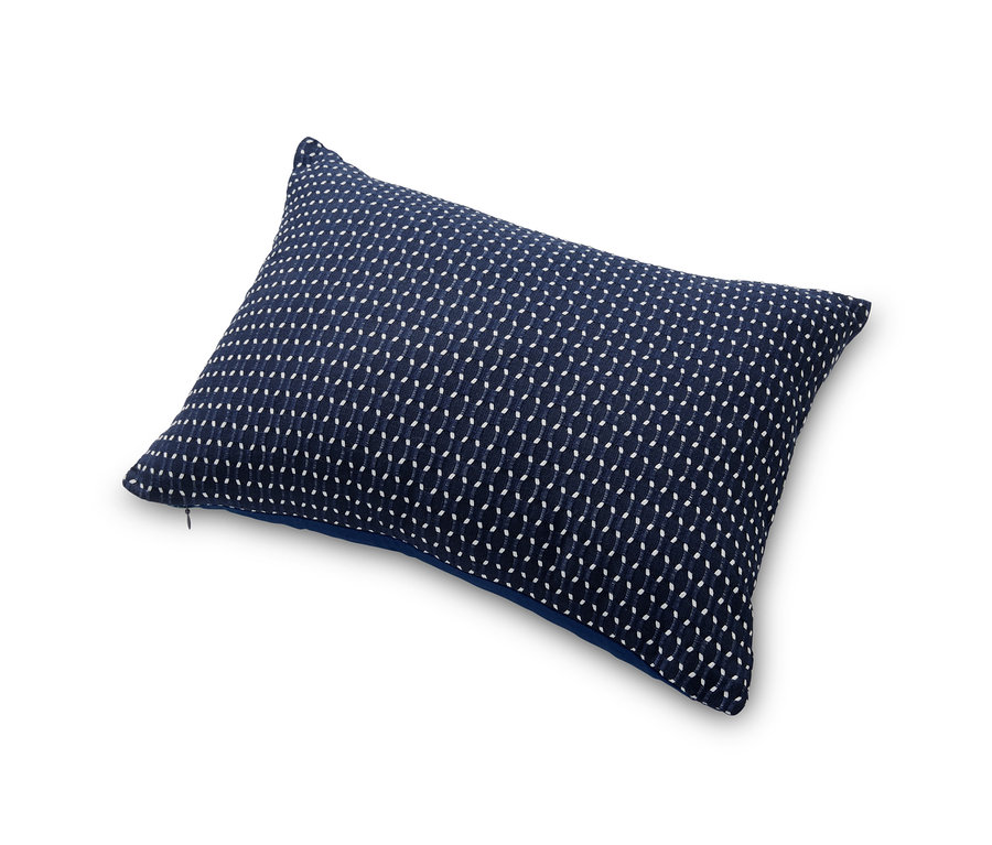 Ein Jacquard-Dekokissen mit einem feinen weißen Muster auf dunkelblauem Grund.