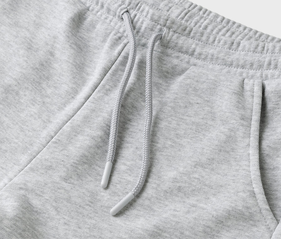 Detailaufnahme einer grauen Jogginghose mit Kordelzug und Tasche.