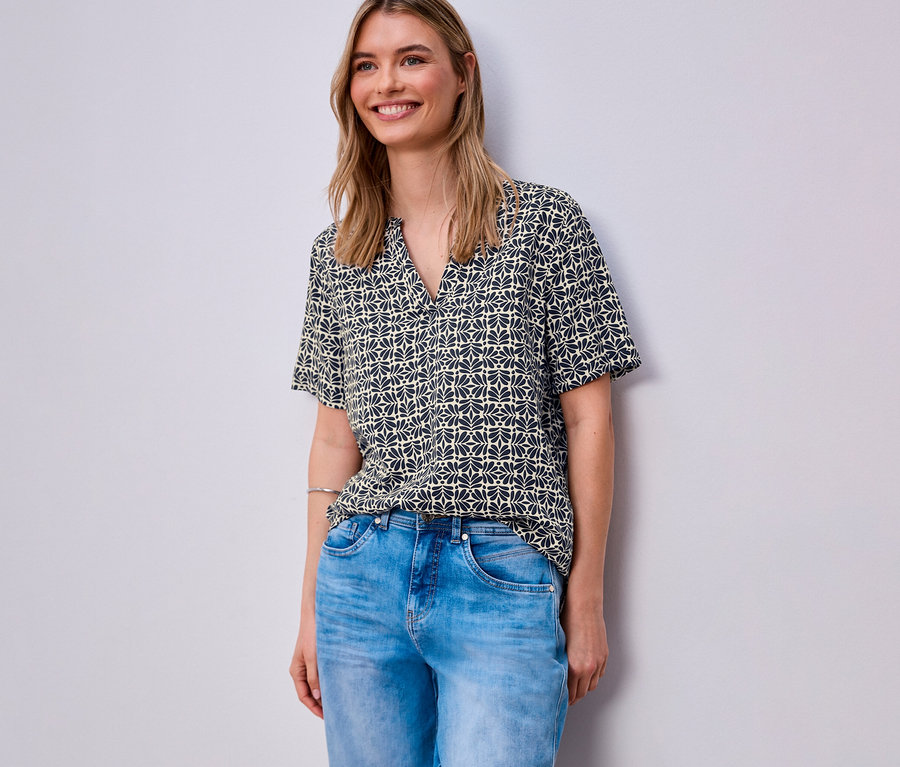 Frau trägt blaue Jeans und eine gemusterte Street One Webbluse.