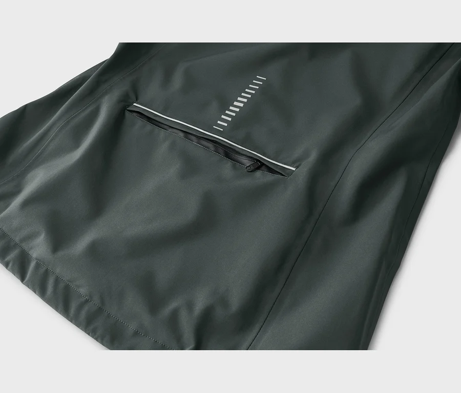 Nahaufnahme einer dunkelgrauen Jacke mit einer Reißverschlusstasche, einem weißen Reflexstreifen und einem Muster aus weißen vertikalen Linien darüber.