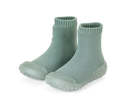 Ein Paar hellgrüne, gerippte Socken-Schuhe mit weichen, genoppten Sohlen.