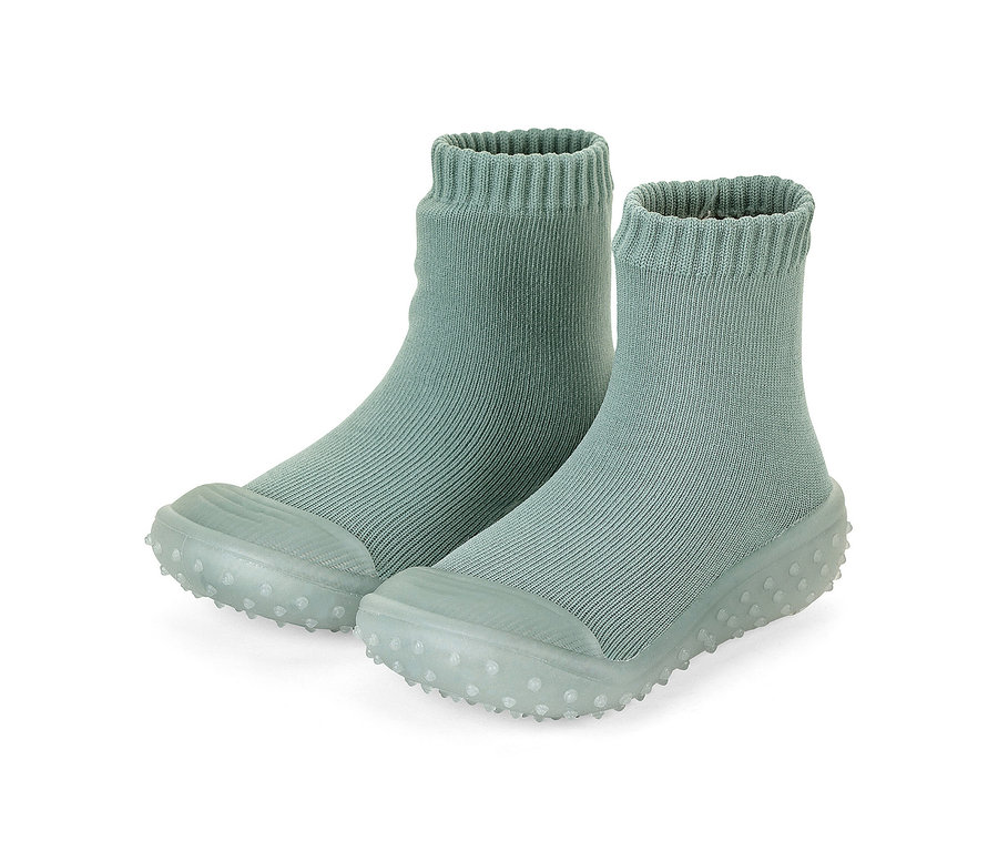 Ein Paar hellgrüne, gerippte Socken-Schuhe mit weichen, genoppten Sohlen.