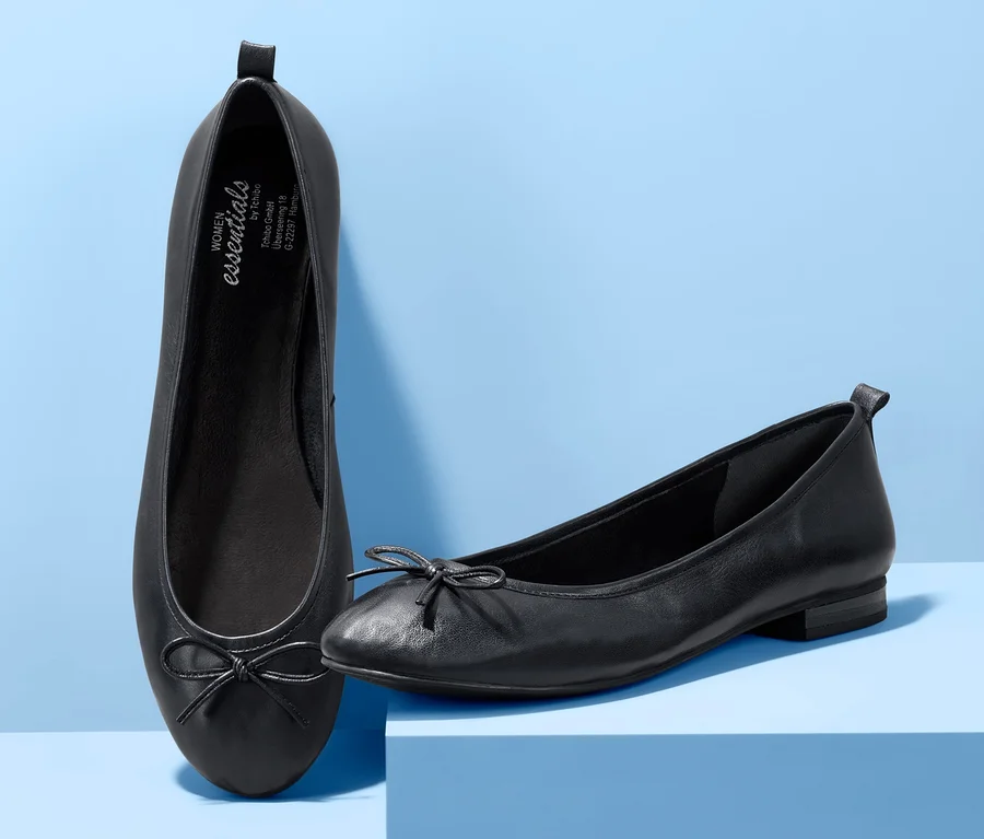 Zwei Leder-Ballerinas auf blauem Hintergrund.