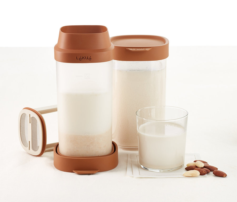 Lékué Nuss- und Getreidemilch-Maker mit Milch, einem Glas Milch und Mandeln.