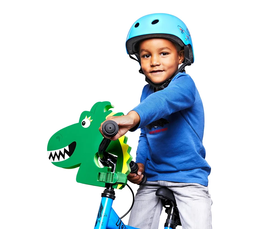 Junge mit blauem Helm auf einem Fahrrad mit Kinder-Lenkeraufsatz »Drache«.