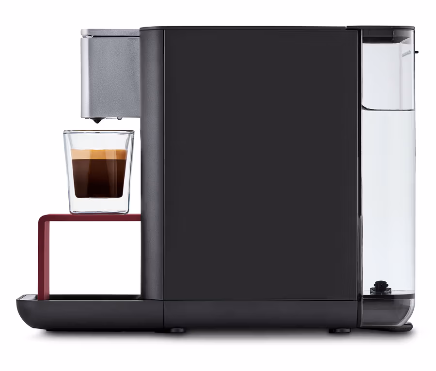 Qbo ESSENTIAL Dark Berry Kaffeemaschine mit einer Tasse Kaffee.