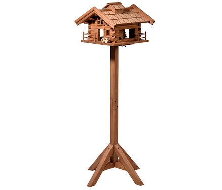 Ein hölzernes Vogelfutterhaus »Tirol« steht auf einer Holzsäule.