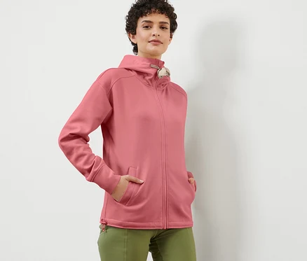 Frau posiert in einer roséfarbenen Kapuzen-Sweatjacke.