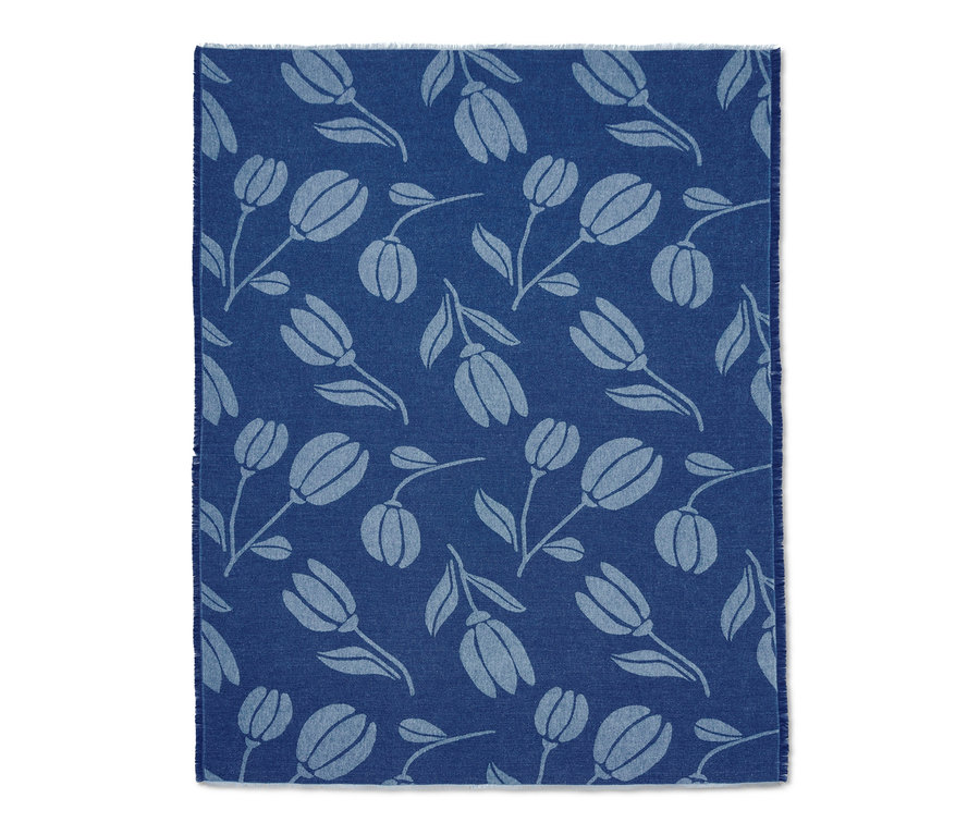 Blaue Wohndecke mit Fransen und Tulpenmuster.
