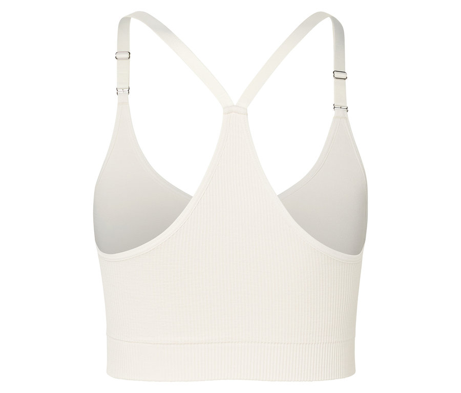 Detailaufnahme eines cremefarbenen Sport-BHs mit Rippstruktur und dünnen Trägern.