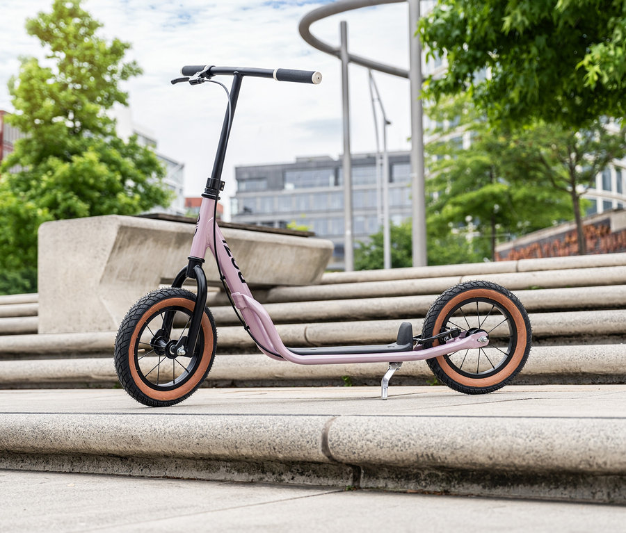 Ein Puky Scooter R 07 L in Pearl Pink steht auf einer Betontreppe im städtischen Raum.