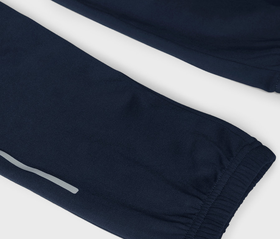 Detailaufnahme einer marineblauen Trainingshose mit reflektierendem Streifen.