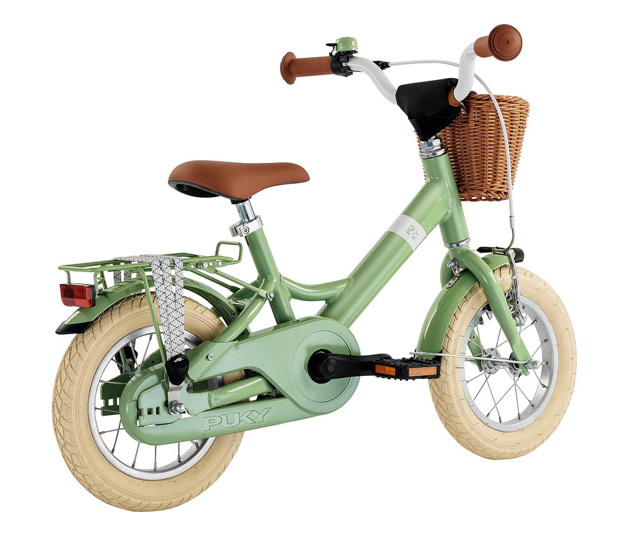 Ein grünes Puky YOUKE CLASSIC 12 Fahrrad mit braunem Sattel und Korb.