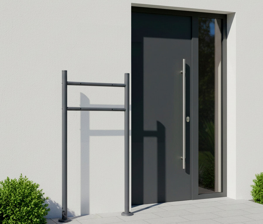 Grauer Fahrradständer vor einer Haustür.