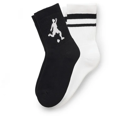 Zwei Socken liegen nebeneinander, eine schwarz mit einem weißen Fußballspieler, die andere weiß mit drei schwarzen Streifen.