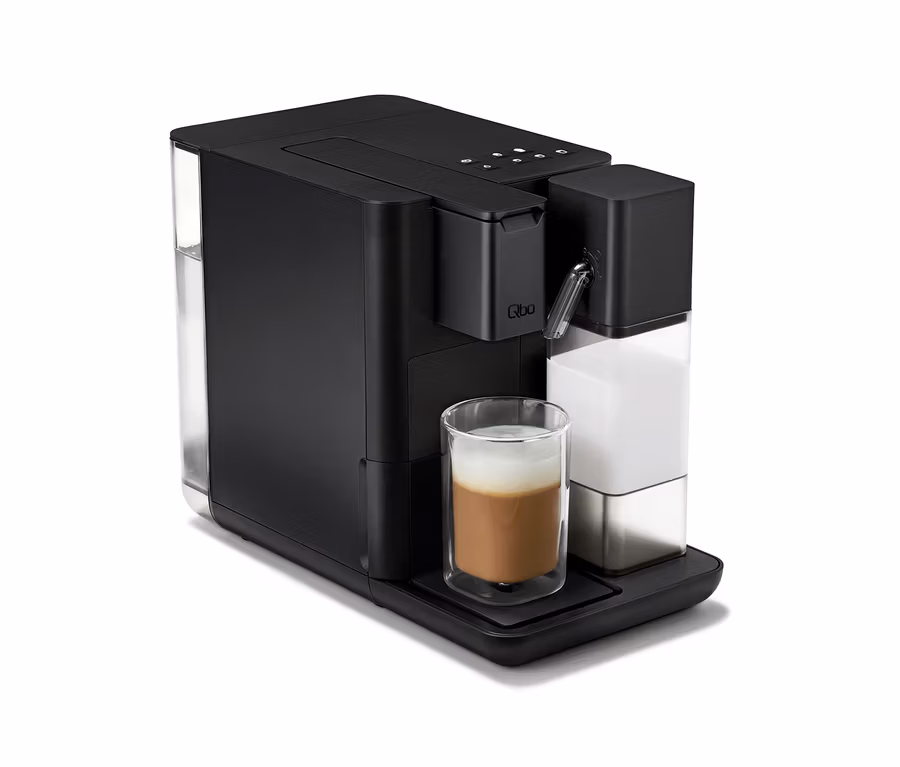 Schwarze Qbo MILK MASTER Velvet Black Kaffeemaschine mit zubereitetem Kaffee in einem Glas.