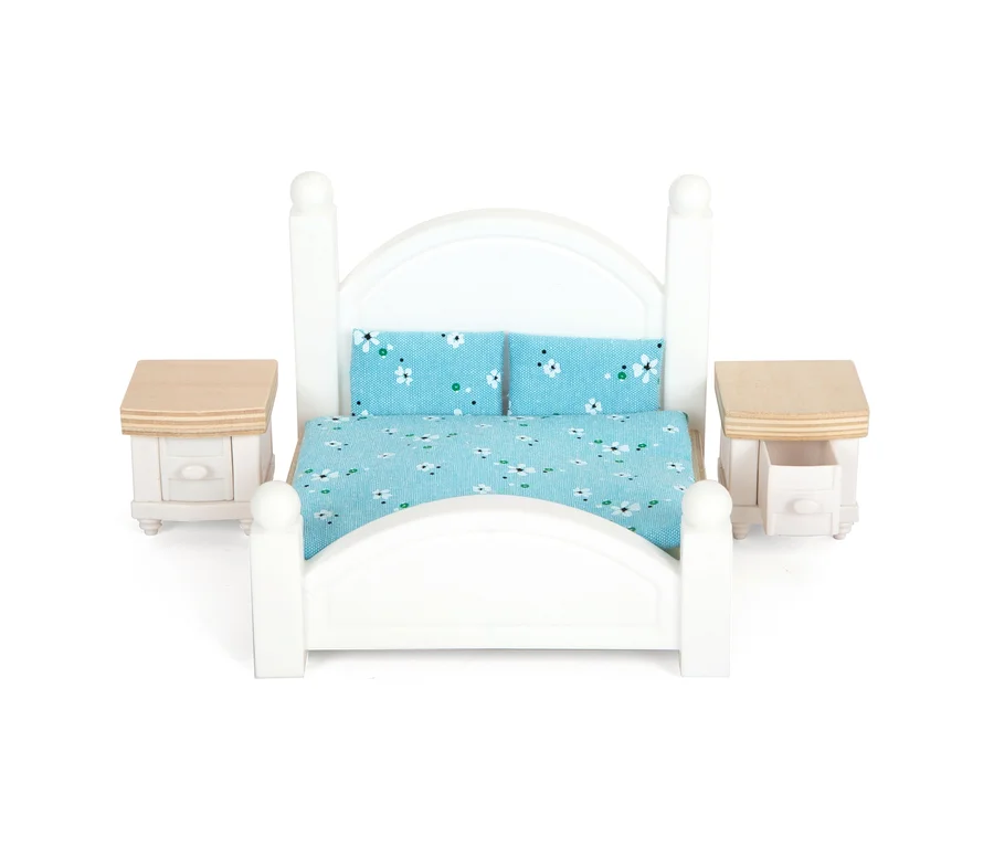 Weißes Bett mit blau-geblümter Bettwäsche und zwei Nachttischen.