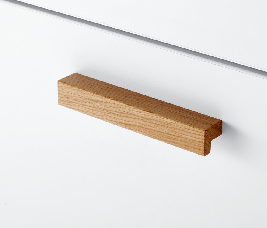 Detail einer Wickelkommode mit Holzgriff.