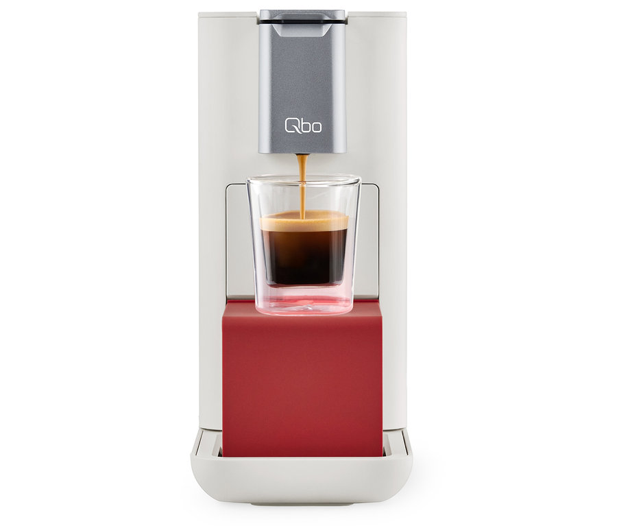 Qbo ESSENTIAL Bright Coral Kaffeemaschine füllt eine Tasse mit Kaffee.