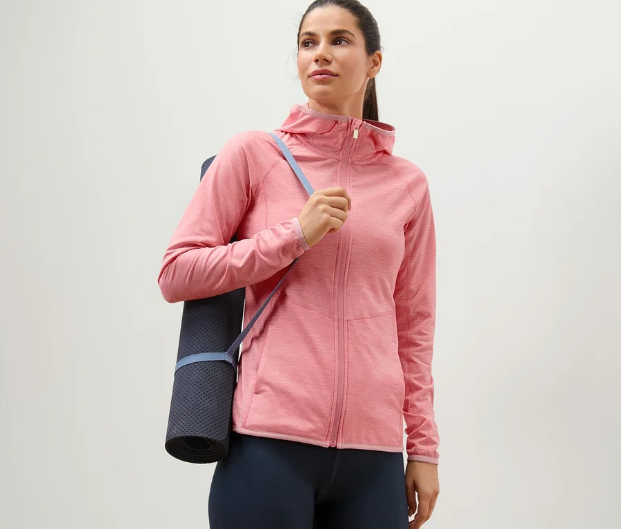 Frau mit Yogamatte über der Schulter trägt eine rosé melierte Sportjacke.