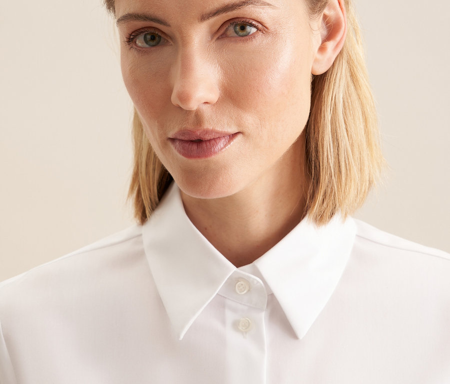 Porträt einer Frau in einer weißen bügelfreien Bluse von Seidensticker.