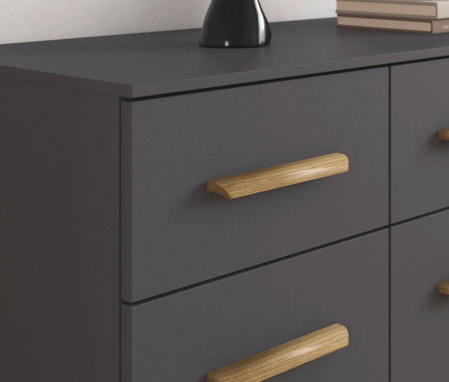 Detail einer grauen Kommode mit vier Schubladen und Holzgriffen.