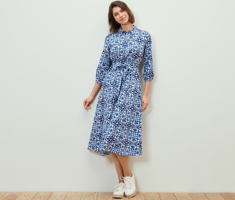 Frau posiert in einem bedruckten Midikleid.